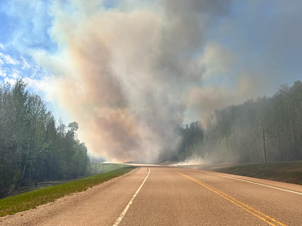 Heavy smoke is visible from an out of control wildfire that prompted instructions for several neighbourhoods in Fort Nelson to evacuate on Friday night. (Submitted by Angela Klondike - image credit)