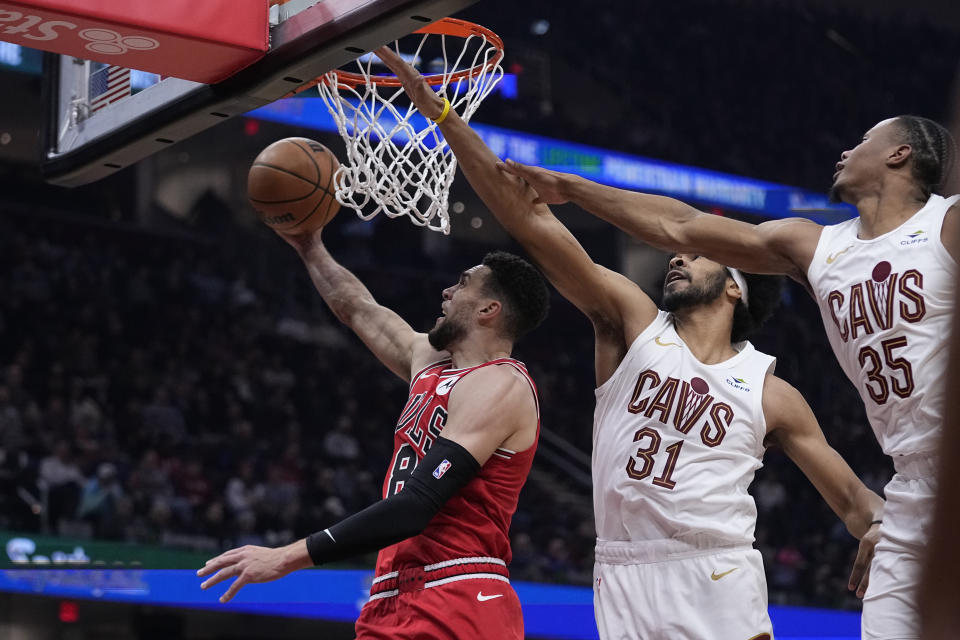 Chicago Bulls guard Zach LaVine (8) goes to the basket in front of Cleveland Cavaliers' Jarrett Allen (31) and forward Isaac Okoro (35) in the first half of an NBA basketball game, Monday, Jan. 15, 2024, in Cleveland. (AP Photo/Sue Ogrocki)