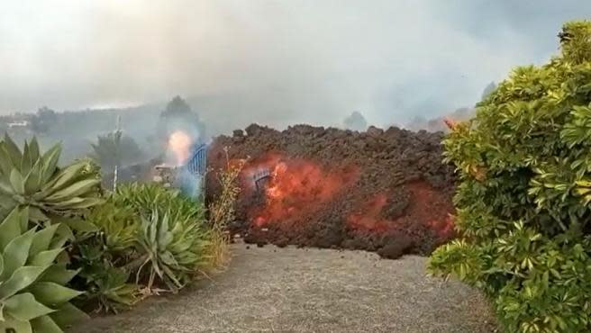 Lengua de lava en La Palma engullendo la verja de entrada a una casa. Se aprecian perfectamente los 