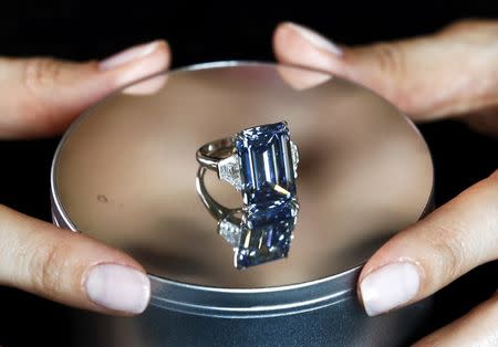 A Christie's employee poses with the 14.62 carats Oppenheimer Blue diamond during a preview in Geneva, Switzerland May 12, 2016. REUTERS/Denis Balibouse