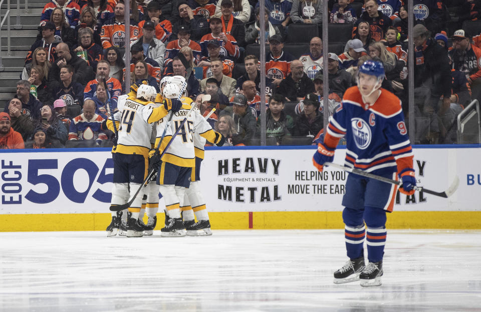 Nashville Predators celebrate a goal as Edmonton Oilers' Connor McDavid (97) skates to the bench during the second period of an NHL hockey game in Edmonton on Saturday Nov. 4, 2023. (Jason Franson/The Canadian Press via AP)