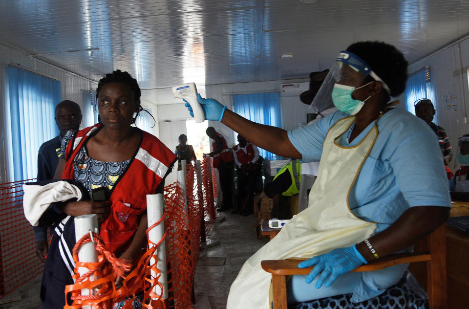 Una enfermera verifica la temperatura de una mujer después de que cruce el punto fronterizo de Mpondwe, entre Uganda y la República Democrática del Congo, como parte de una de las pruebas de detección del ébola. (Foto: Newton Nabwaya / Reuters).