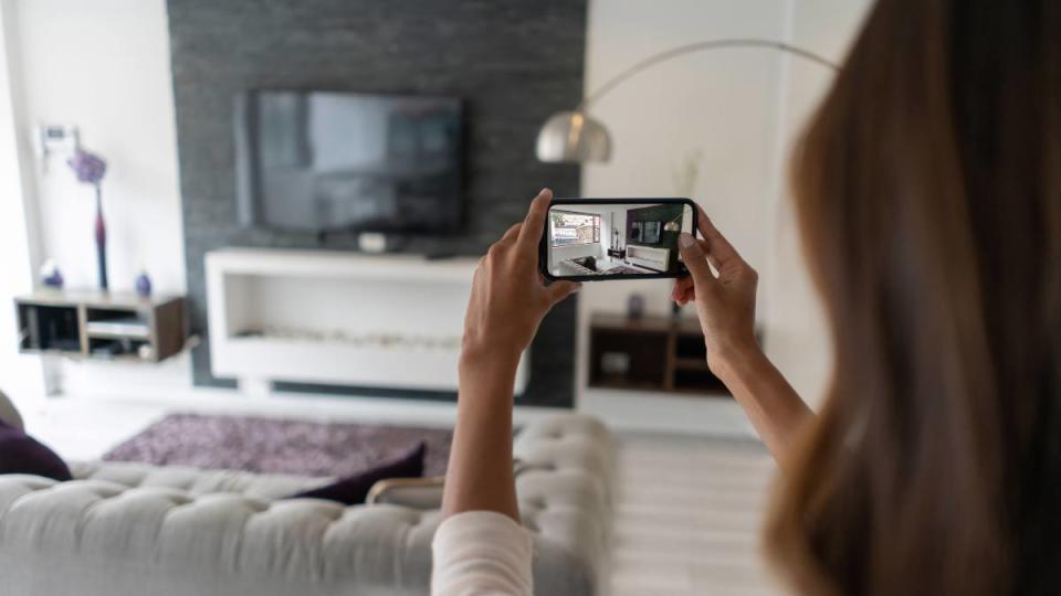 evening work from home jobs: Real estate agent making a virtual tour of a house using her cell phone