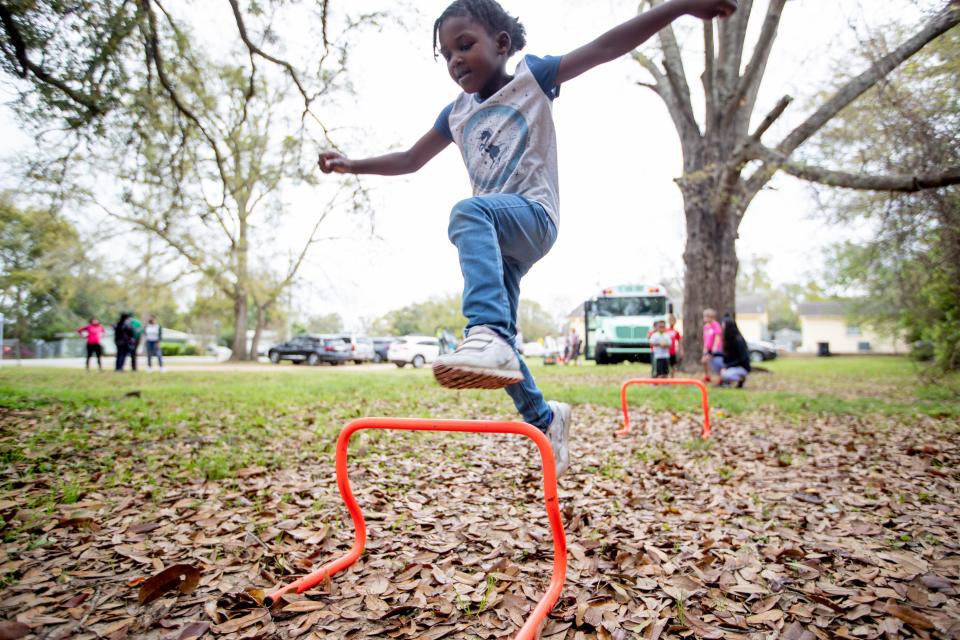 A child jumps over an obstacle during a "popup preschool" facilitated by three local women in the Greater Bond and South City communities Wednesday, March 17, 2021.Wednesday, March 17, 2021.