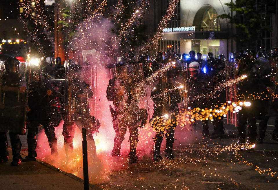 Image: Fireworks go off in front of police, who with protesters in front of police headquarters in St. Louis (Colter Peterson / AP)