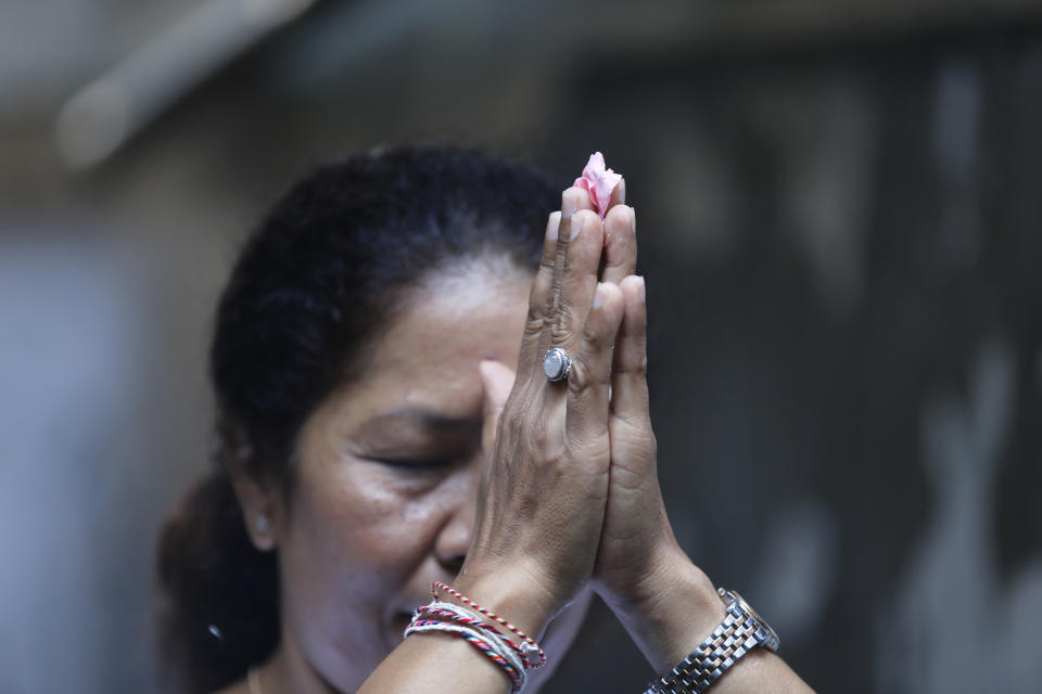 Ni Luh Erniati prays at a temple in her home in Bali, Indonesia on Friday, April 26, 2019. Erniati's husband, Gede Badrawan, was killed in the 2002 Bali bombings. She has since reconciled with a former bombmaker whose brothers helped orchestrate the Bali attack as part of a peacebuilding program bringing together ex-terrorists and victims. (AP Photo/Firdia Lisnawati)