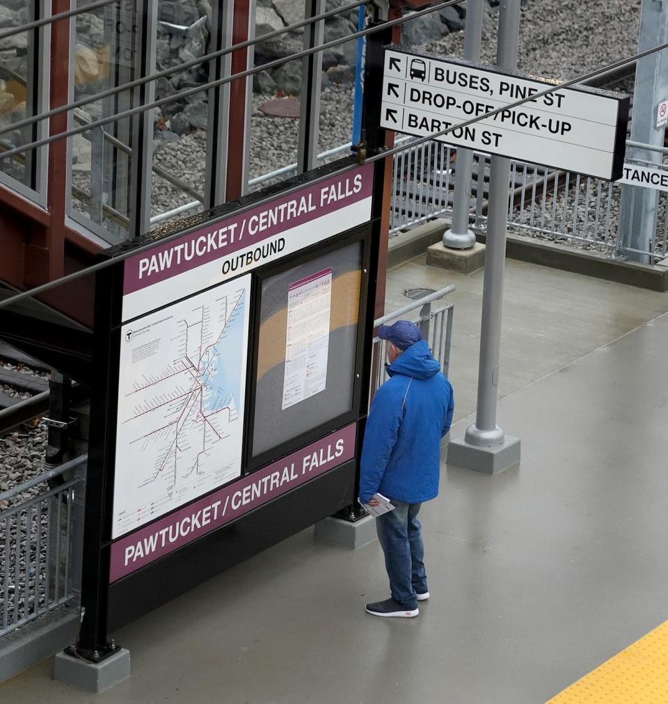 A man reads the train schedule at the Pawtucket-Central Falls MBTA station's opening day on Monday.