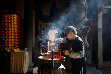 Chen Hong-zhi, 26, who suffers from short-term memory loss, prays at a temple to be helped to find his lost mobile phone, on Beipu Old Street area in Hsinchu, Taiwan, October 26, 2018. REUTERS/Tyrone Siu