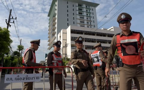 Thai policemen block a road leading to the hospital where the boys rescued after being trapped in a nearby cave for nearly two weeks have being brought for observation - Credit: TANG CHHIN SOTHY /AFP