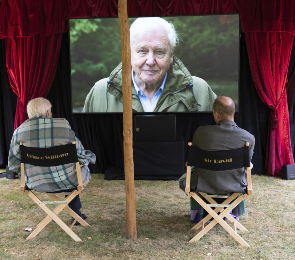 In this undated handout photo issued by WWF on Saturday, Sept. 26, 2020, British Naturalist Sir David Attenborough, sits with Prince William for a private outdoor screening of his upcoming film, David Attenborough: A Life On Our Planet, at Kensington Palace, London.(WWF via AP)