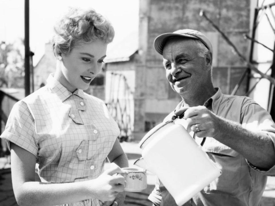 A man pours a cup of coffee for actress Janet Leigh in 1952.