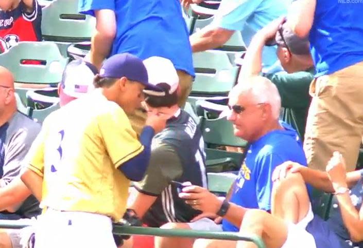 Brewers shortstop Orlando Arcia steals a bite of ice cream from an unsuspecting fan during Saturday's game at Miller Park. (MLB)