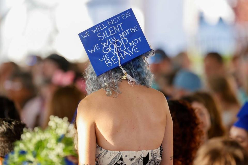 A graduate sends a mortarboard message during New College of Florida’s official commencement ceremony on Friday, May 19, 2023 in Sarasota. A student-led alternative commencement was held Thursday in protest of state-mandated changes at the school.