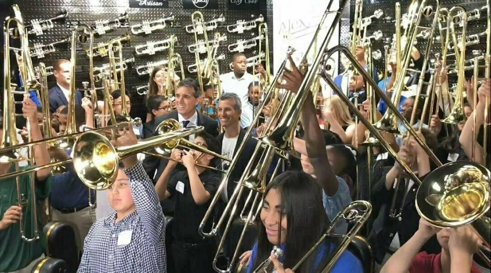Fifty students surround Max Schachter and Fred Schiff to blast a B-flat on their new Alex Tribute Trombones Saturday, May 11, 2019 at All County Music in Tamarac, Fla. Fifty special trombones have been given out to band students throughout Florida in honor of 14-year-old Alex Schachter, who was a trombone player in the marching band at Marjory Stoneman Douglas High School and who died in the Parkland high school shooting. (Wayne K. Roustan/South Florida Sun-Sentinel via AP)