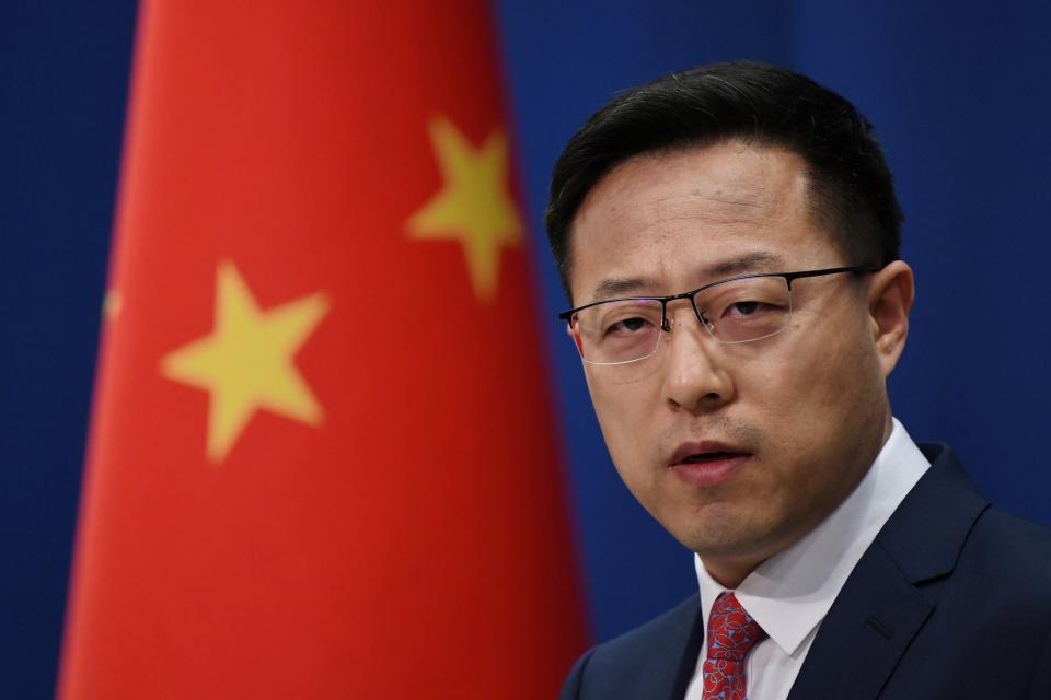 Chinese spokesperson Zhao Lijian is seen in front of a Chinese flag at a press conference