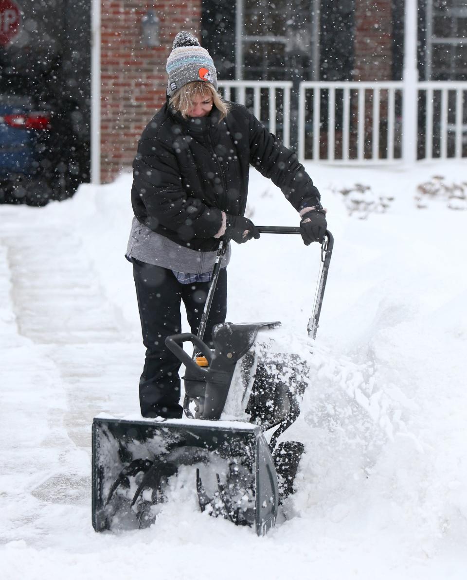 Stephanie Valentine cleared her driveway in Plain Township on Monday.