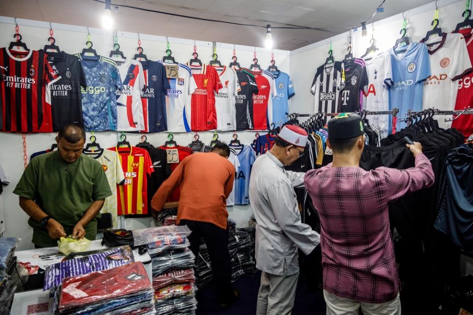 Penjual kaos replika Ahmed Hamed kesulitan menghadapi pemburu barang murah yang menawarinya harga murah. — Foto oleh Ferdous Latif