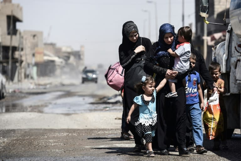 Iraqis fleeing the Old City of Mosul arrive in the industrial district of the city on June 23, 2017