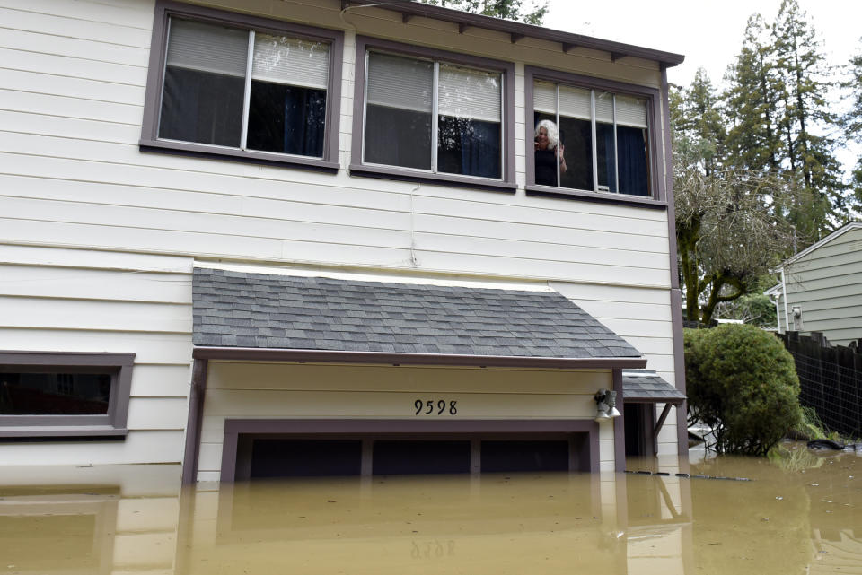 Cheryl Hughes looks out of her window of her home that is surrounded by flood waters of the Russian River in Forestville, Calif., on Feb. 27, 2019. (Photo: Michael Short/AP)