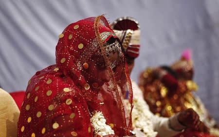 A bride and groom attend a mass wedding ceremony in New Delhi February 15, 2014. REUTERS/Adnan Abidi/Files