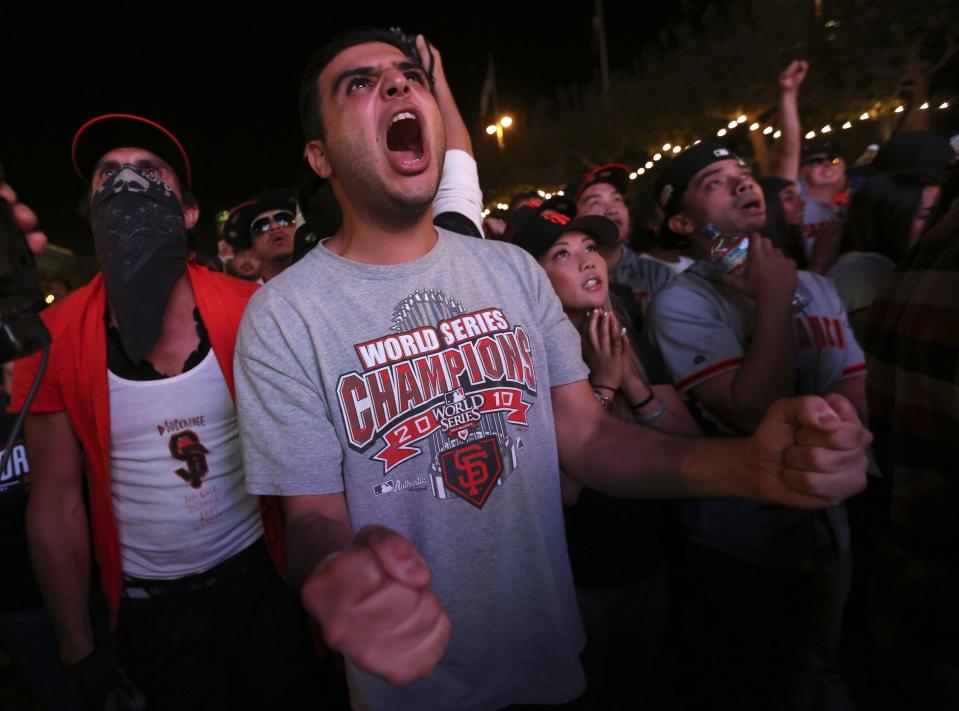 Fan Elior Ilishah celebrates during the San Francisco Giants win over the Kansas City Royals in the World Series during a television viewing event at the Civic Center in San Francisco