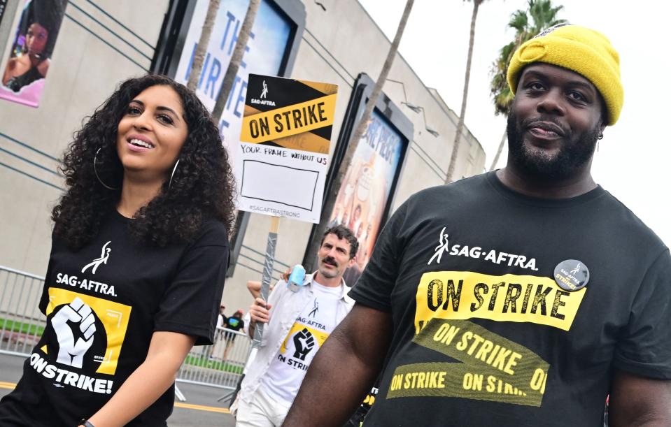 Strikers carry signs as writers and actors stage a solidarity march through Hollywood to Paramount Studios on Sept. 13, 2023, amid a halt in movie and TV production as the dual labor shortages continue. The Writers Guild of America has been on strike since early May and the SAG-AFTRA actors' union joined the writers on the picket lines in July.