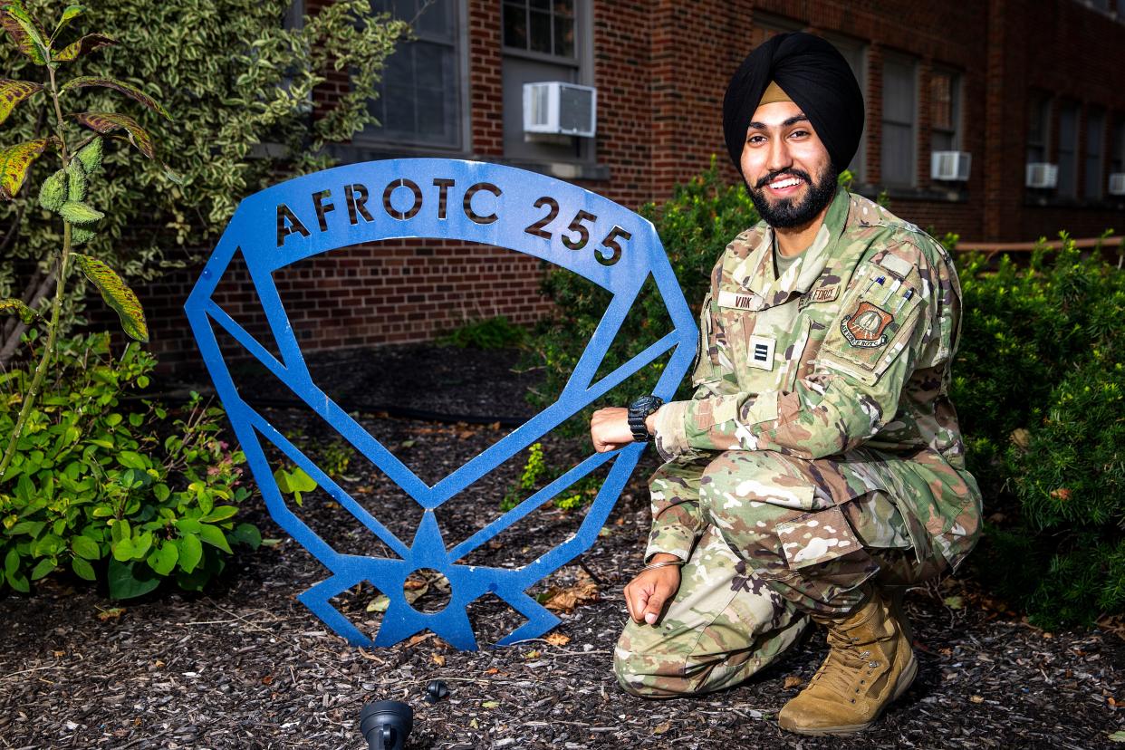 University of Iowa junior Gursharan Virk poses next to an Air Force ROTC logo Thursday in Iowa City. Virk, who wants to become a pilot, was recently given permission to wear his traditional Sikh turban and beard while in uniform.