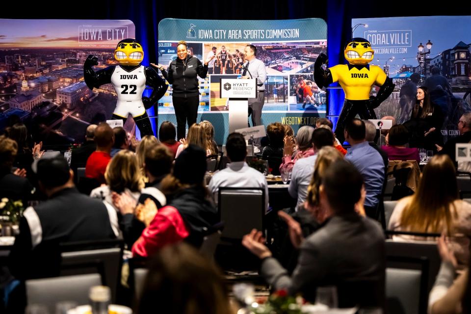 Iowa women's basketball assistant coach Raina Harmon (left) poses next to a statue of Basketball Herky (22) with Mitch Gross as he unveiled Just Herky from Herky on Parade III at the Think Iowa City and Iowa City Area Sports Commission annual meeting, Wednesday, Feb. 14, 2024, in Coralville, Iowa.