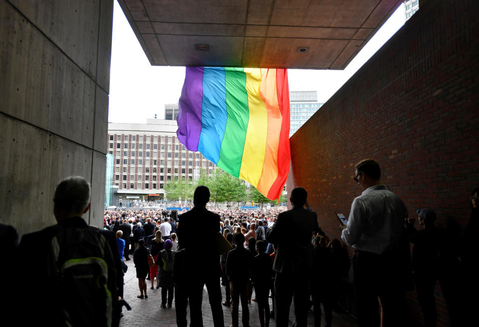 Attendees pause under a giant pride flag during a vigil for the victims of the mass shooting at Orlando's Pulse nightclub, in Boston, Massachusetts, U.S. June 13, 2016.&nbsp;