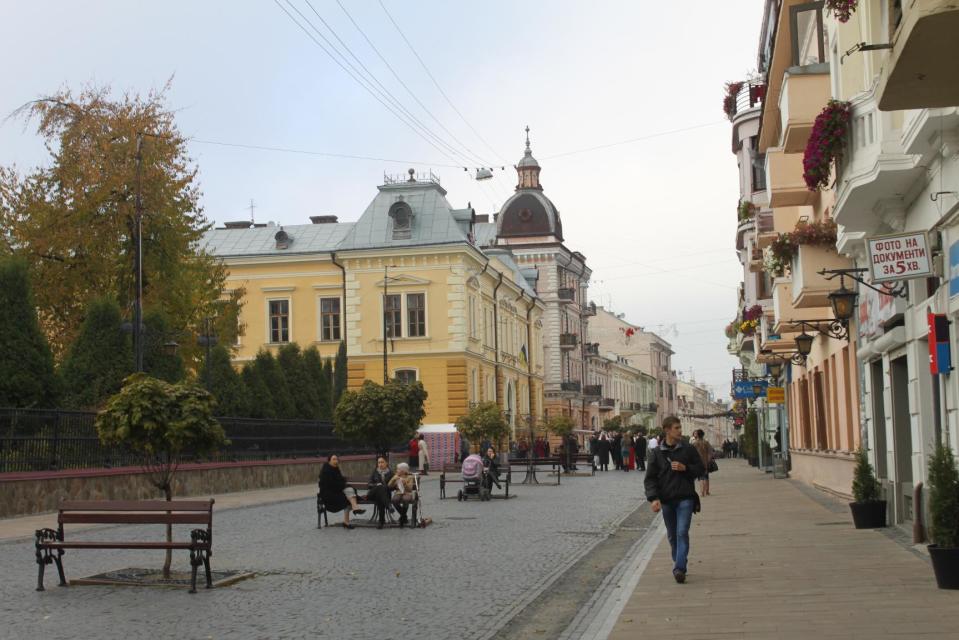 In this photo taken on Oct. 21 2012, a man walks down the pedestrian-only Olha Kobylianska street in Chernivtsi, a city of 250,000 in southwestern Ukraine. Known as the Little Paris or, alternatively, the Little Vienna of Ukraine, Chernivtsi is a perfect place for a quiet romantic weekend trip and a crash course in the painful history of Europe in the 20th century. (AP Photo/Maria Danilova)