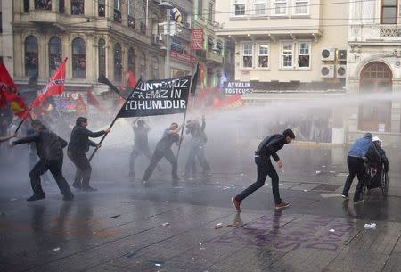 Protesters run away from water canon fired by the riot police during a demonstration blaming the ruling AK Party (AKP) government for the mining disaster in western Turkey, in central Istanbul May 14, 2014. REUTERS/Cevahir Bugu