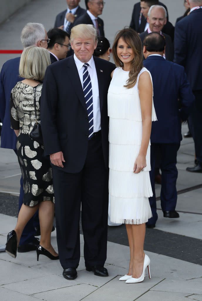 <p>The first lady wore a <a href="http://www.vogue.com/article/melania-trump-michael-kors-christian-louboutin-g20-summit-celebrity-first-lady-style" rel="nofollow noopener" target="_blank" data-ylk="slk:high-necked white flapper-inspired dress by Michael Kors;elm:context_link;itc:0;sec:content-canvas" class="link ">high-necked white flapper-inspired dress by Michael Kors</a> to a concert and dinner for world leaders at the G20 Summit in Hamburg.</p>