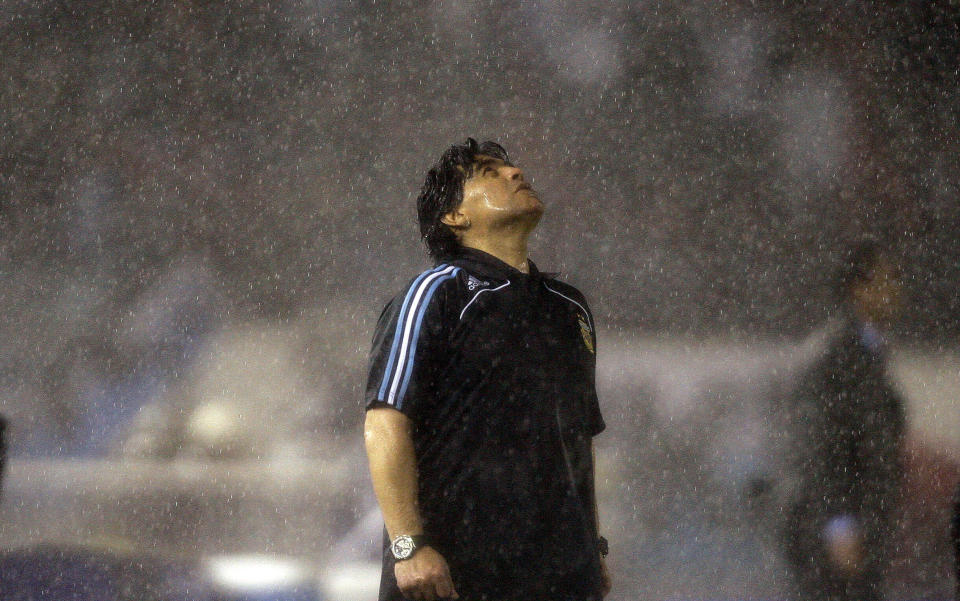 FILE - In this Oct. 10, 2009 file photo, under the pouring rain, Argentina's coach Diego Maradona looks up under the pouring rain during a 2010 World Cup qualifying soccer match against Peru, in Buenos Aires. Argentina won 2-1. The Argentine soccer great who was among the best players ever and who led his country to the 1986 World Cup title before later struggling with cocaine use and obesity, died from a heart attack on Wednesday, Nov. 25, 2020, at his home in Buenos Aires. He was 60. (AP Photo/Natacha Pisarenko, File)