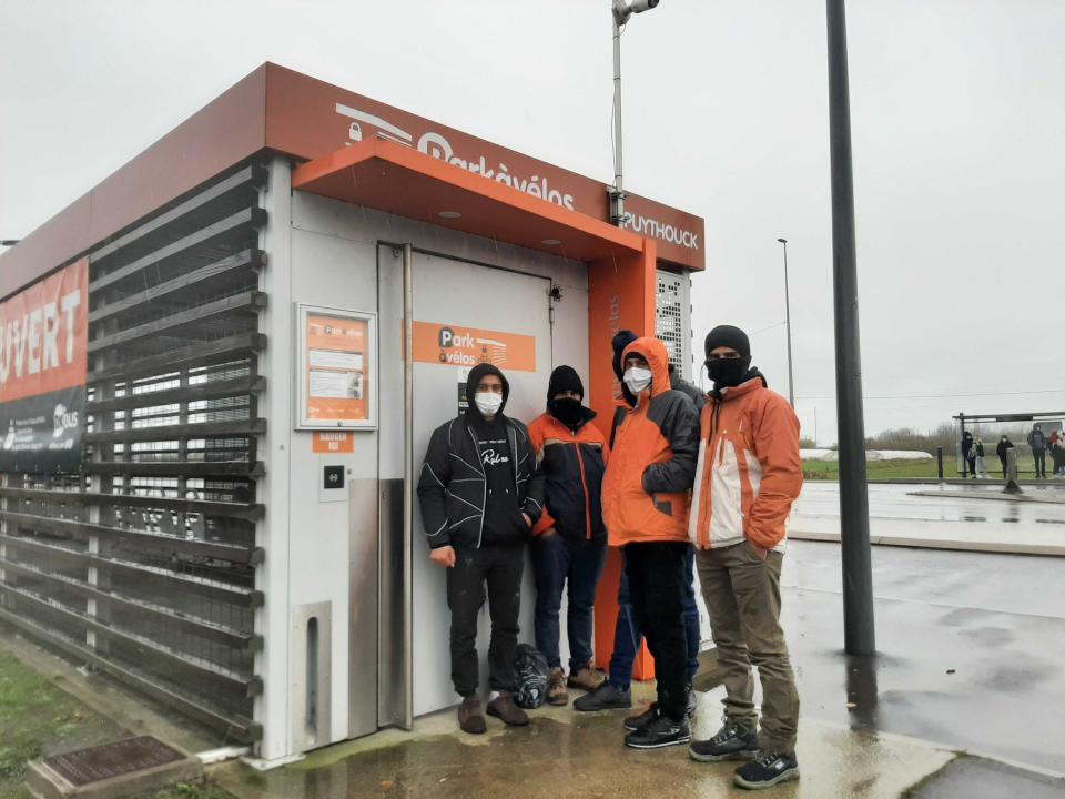 A group from Iran attempt to shelter from the rain in Dunkirk while contemplating an attempt to cross the Channel (Zoe Tidman/The Independent)