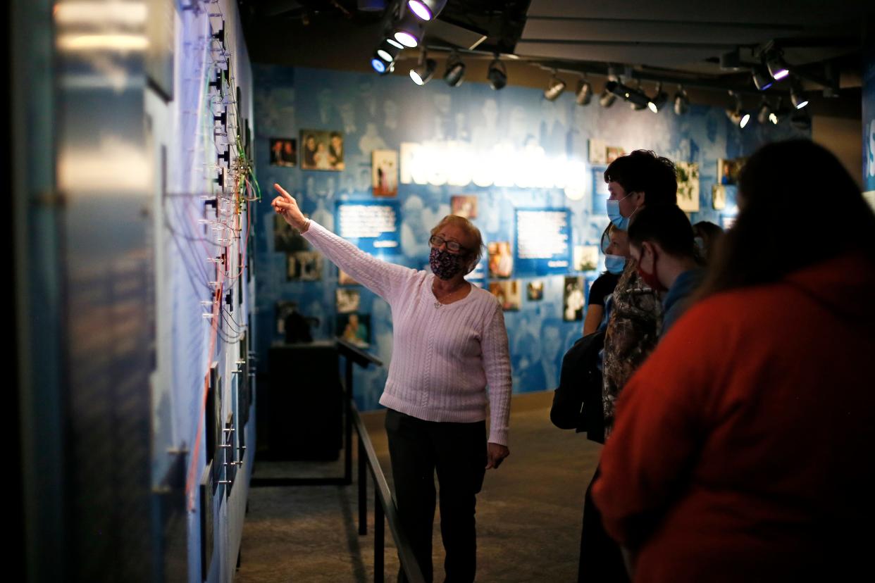 Julie Gore explains an installation showing the paths that local Holocaust survivors took from their European homes to settle in the Cincinnati area at the Holocaust & Humanity Center in the Queensgate neighborhood of Cincinnati.