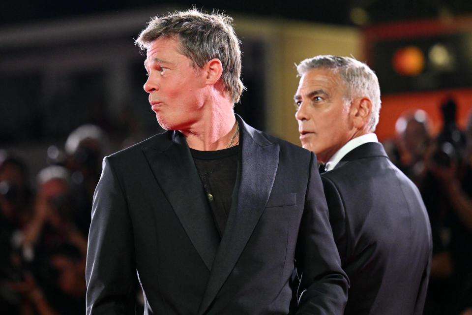 El actor George Clooney (d) bromea con el actor Brad Pitt durante la alfombra roja de la película «Wolfs» presentada fuera de concurso durante el 81º Festival Internacional de Cine de Venecia en Venice Lido, el 1 de septiembre de 2024. (Foto de Alberto PIZZOLI / AFP) (Foto de ALBERTO PIZZOLI/AFP via Getty Images)