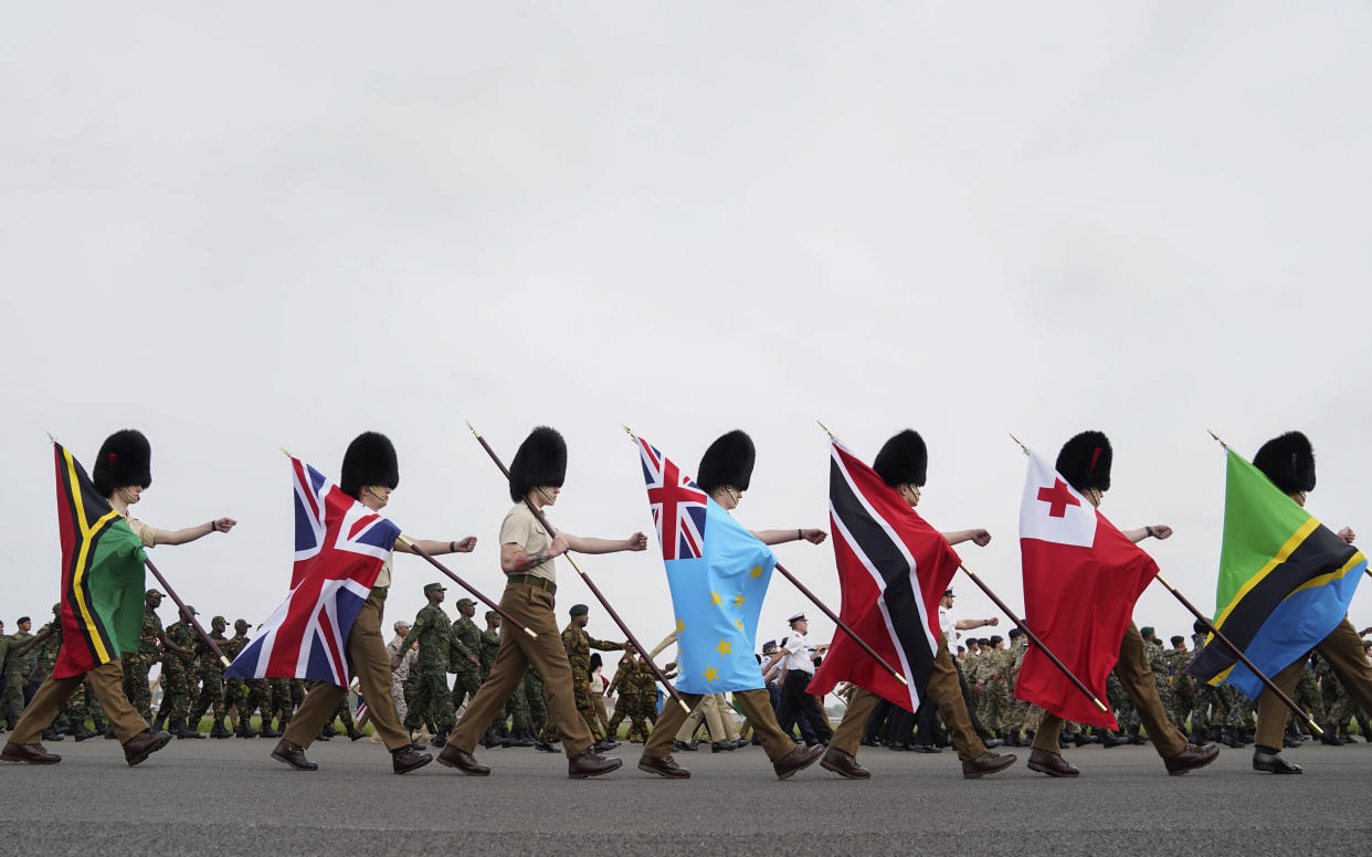 FILE - Guards carry flags from Commonwealth countries during a full tri-service and Commonwealth rehearsal at RAF Odiham in Hook, England, Sunday, April 30, 2023, ahead of their involvement in the second procession that accompanies King Charles III and Queen Camilla from Westminster Abbey back to Buckingham Palace. When King Charles III is crowned on Saturday, May 6, 2023, soldiers carrying flags from the Bahamas, South Africa, Tuvalu and beyond will be marching alongside British troops to honor King and Country. (Andrew Matthews/PA via AP, File)