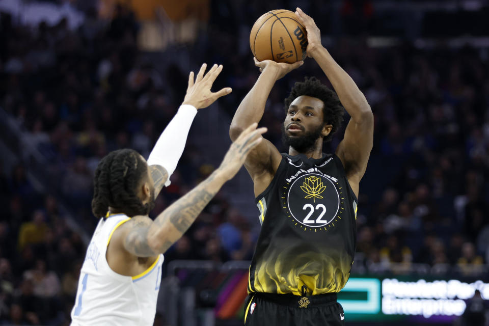 Golden State Warriors forward Andrew Wiggins (22) shoots against Los Angeles Lakers guard D'Angelo Russell (1) during the first half of an NBA basketball game in San Francisco, Saturday, Feb. 11, 2023. (AP Photo/Jed Jacobsohn)