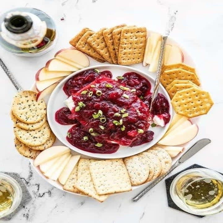 cranberry and cream cheese dip surrounded by crackers on a platter