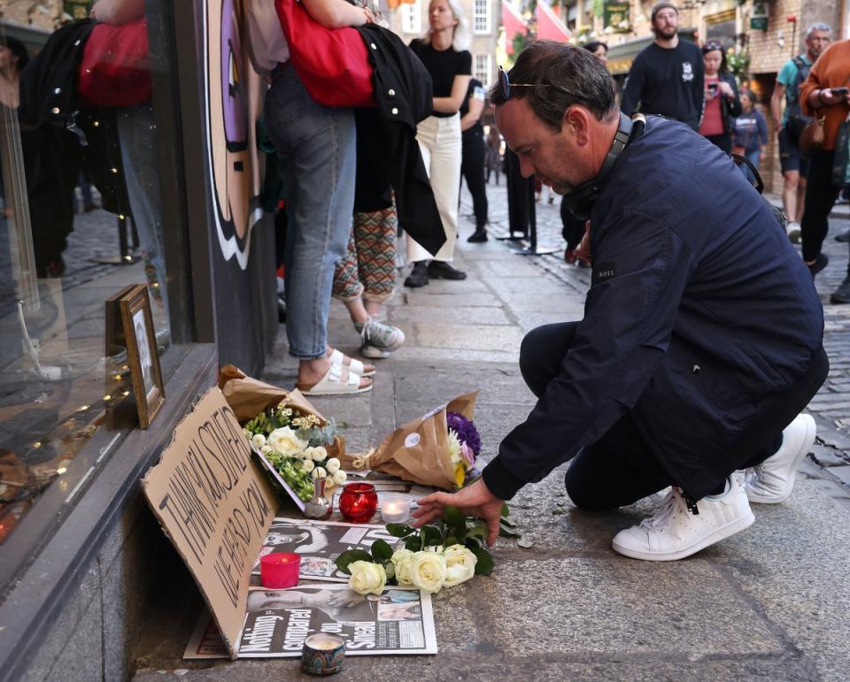 People gather to pay tribute to Sinead O’Connor at the Irish Rock ‘n’ Roll Museum in the Temple Bar area of Dublin (PA)