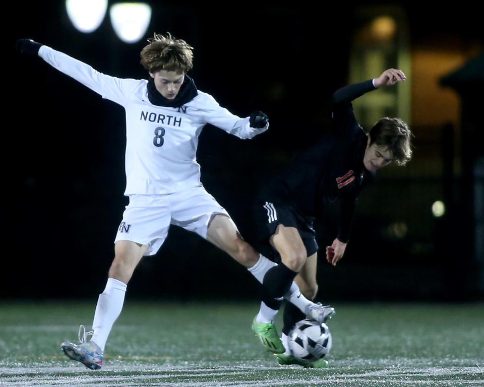 Plymouth North's Bradlee Sorensen looks to get the ball off the foot of Oliver Ames's Casey Milliken during second half action of the Division 2 state semifinal game against Oliver Ames at Marshfield High School on Wednesday, Nov. 16, 2022. Oliver Ames won 2-0.