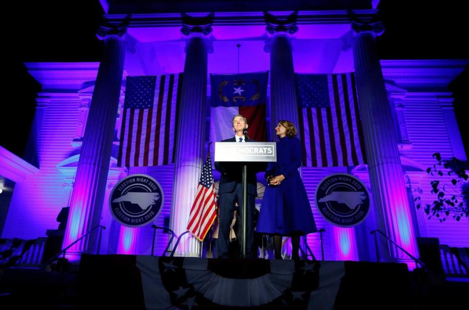 Gov. Roy Cooper, standing with his wife Kristin, speaks outside the North Carolina Democratic Party headquarters in Raleigh, N.C., Tuesday, Nov. 3, 2020.