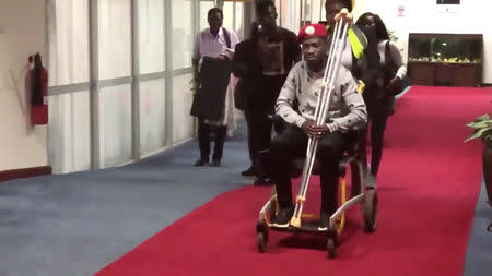 Bobi Wine is seen in a wheelchair just before his departure at Entebbe International Airport, in Entebbe, Uganda, August 31, 2018 in this still image taken from a social media video on September 1, 2018. NICHOLAS OPIYO/via REUTERS