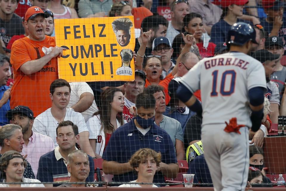 A fan holds a sign as Houston Astros' Yuli Gurriel heads to the dug out after scoring on a single by Michael Brantley during the third inning of a baseball game against the Boston Red Sox, Wednesday, June 9, 2021, in Boston. (AP Photo/Michael Dwyer)