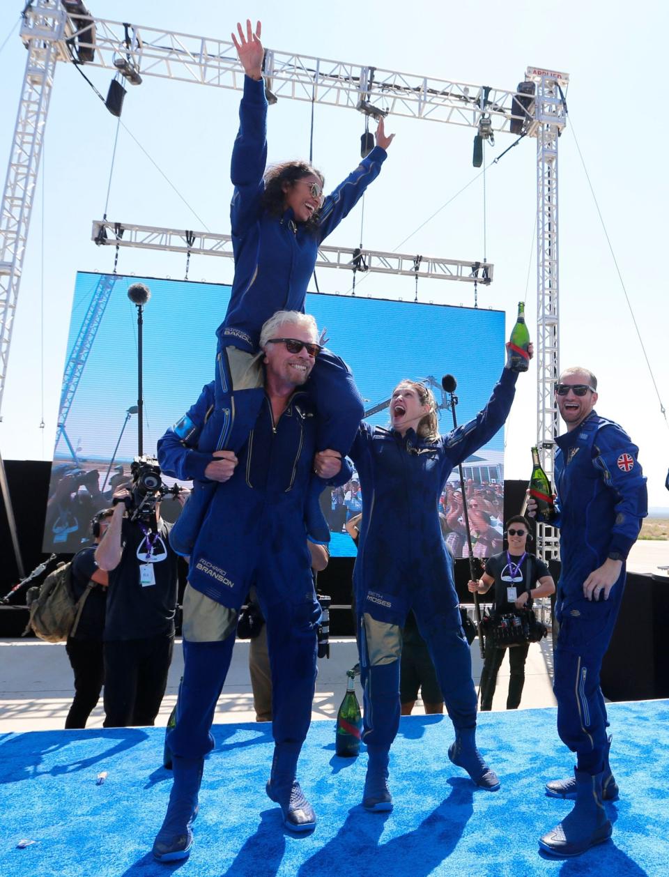 richard branson virgin galactic crewmates celebrate spaceflight with champagne on stage