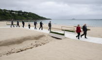 United Kingdom Prime Minister Boris Johnson and German Chancellor Angela Merkel walk with French President Emmanuel Macron, U.S. President Joe Biden, Canadian Prime Minister Justin Trudeau, European Commission President Ursula von der Leyen, Italian Prime Minister Mario Draghi, Japanese Prime Minister Yoshihide Suga and European Council President Charles Michel to the family photo at the G7 Summit in Carbis Bay, England on Friday June 11, 2021. (Adrian Wyld/The Canadian Press via AP)