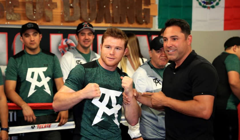 Saul "Canelo" Alvarez, left, poses with Oscar De La Hoya during a media workout at the House of Boxing Gym in San Diego on April 25.
