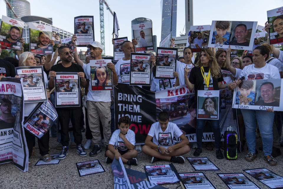 Relatives of people kidnapped by Hamas militants hold the pictures of their loved ones during a protest calling for their return, in Tel Aviv, Israel, Thursday, Oct. 26, 2023. On Oct. 7, more than 1,400 people were killed and over 220 captured in an unprecedented, multi-front attack by the militant group that rules Gaza. (AP Photo/Ohad Zwigenberg)