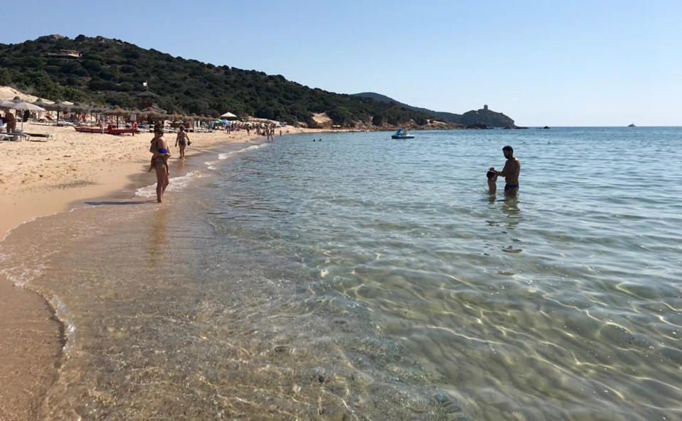 In this June 29, 2019 photo, people enjoy the white sand and pristine waters of Chia beach, on the Italian island of Sardinia, Italy. A French couple could face up to six years in jail for taking around 40 kg (88.1lbs) of white sand from Chia beach on the Italian island of Sardinia. (AP Photo/Karl A.Ritter)