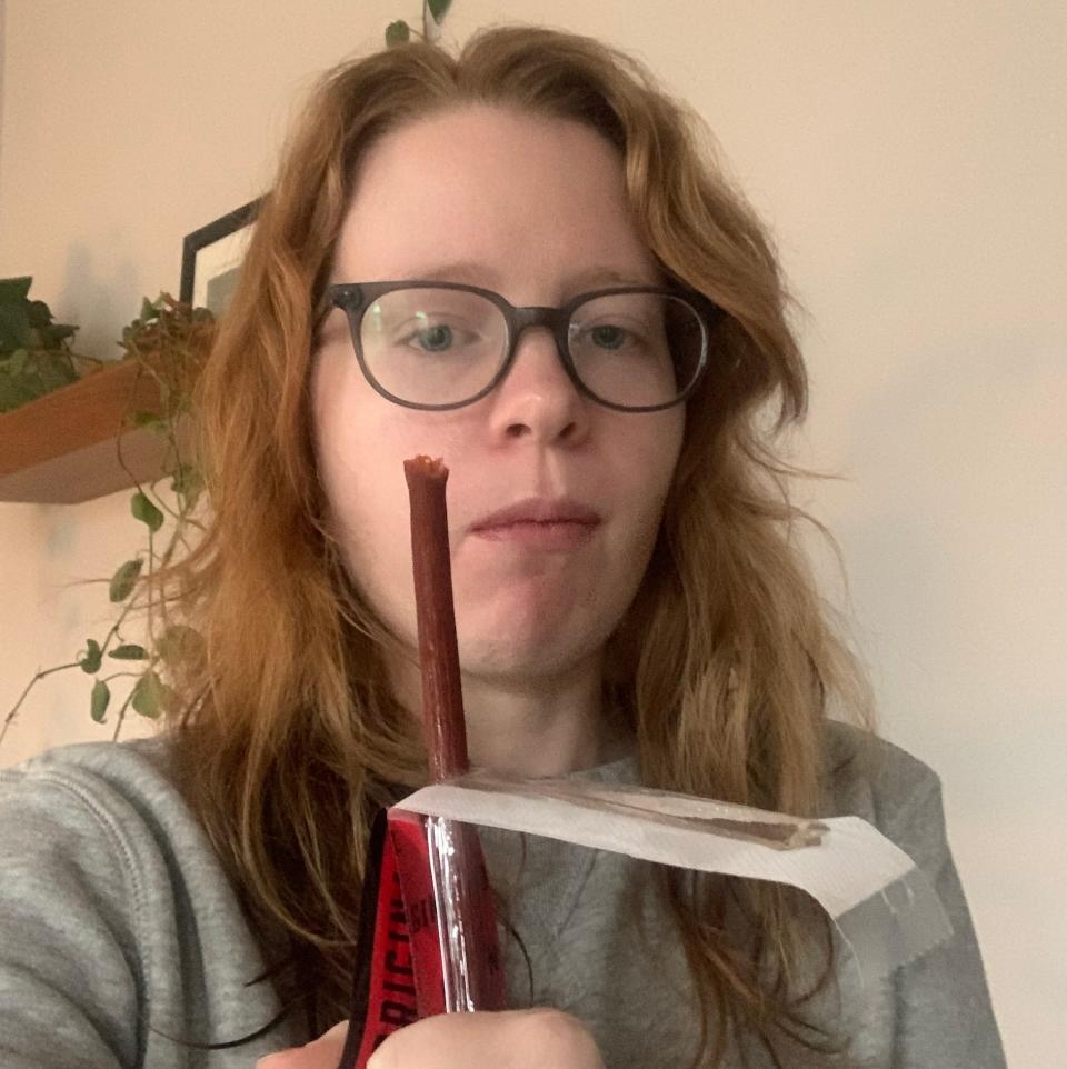 A woman enjoying beef jerky.